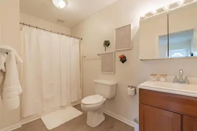 a white bathroom with a toilet and a sink at University Suite 