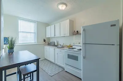 a kitchen with a white refrigerator and a table at University Suite 