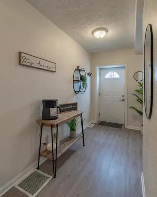 a living room with a table and a door at University Suite 