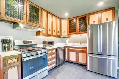 a kitchen with wooden cabinets and stainless steel appliances at Retro Refuge On Woodstock Dr in Van Wert
