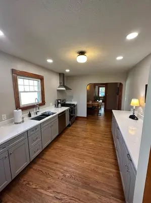 a large kitchen with white counter tops and wooden floors at Vintage Charm on Elson Ave in Van Wert