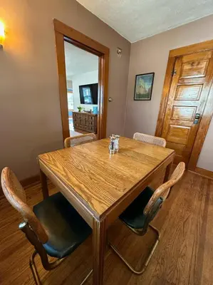 a dining room with a wooden table and chairs at Vintage Charm on Elson Ave in Van Wert