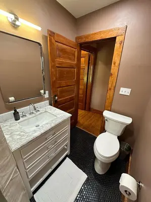 a bathroom with a toilet and a sink and a mirror at Vintage Charm on Elson Ave in Van Wert