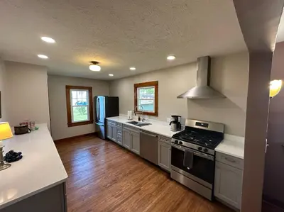 a kitchen with stainless steel appliances and wooden floors at Vintage Charm on Elson Ave in Van Wert