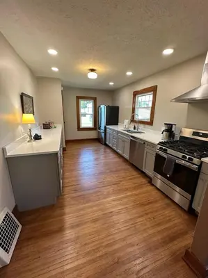 a kitchen with stainless steel appliances and wooden floors at Vintage Charm on Elson Ave in Van Wert