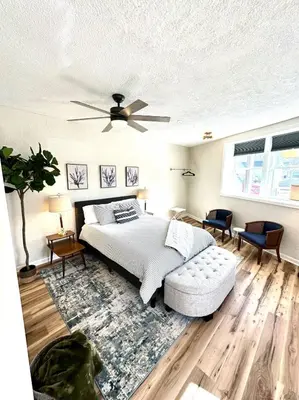 a bedroom with a bed and a ceiling fan at University Suite 