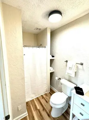 a bathroom with a white toilet and a shower at University Suite 