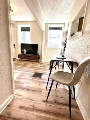 a living room with a table and a television at University Suite 