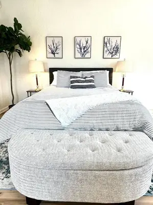a large bed with a large ottoman in a bedroom at University Suite 