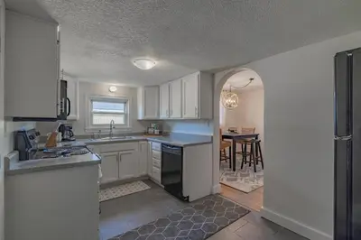 a kitchen with white cabinets and a dining room at Lodge On Landess in Marion