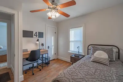 a bedroom with a bed with a desk and a ceiling fan at Lodge On Landess in Marion