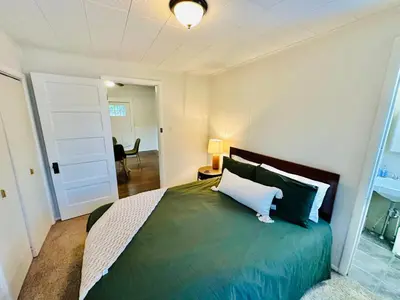 a bedroom with a large bed with a white pillow at Campus Haven in Kiley