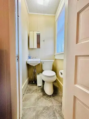 a bathroom with a white toilet and a sink at Campus Haven in Kiley