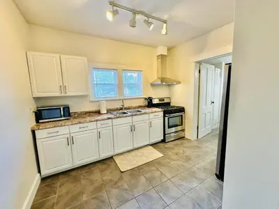 a kitchen with white cabinets and a sink at Campus Haven in Kiley