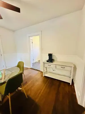 an empty living room with a table and a chair at Campus Haven in Kiley
