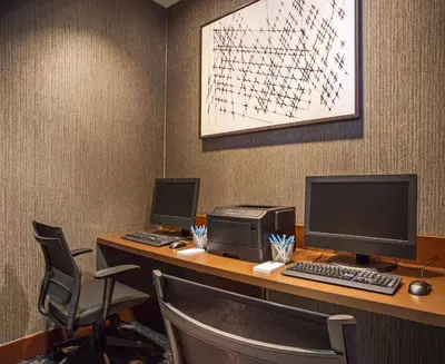 an office with two monitors and a computer on a desk at Hyatt Place Cincinnati Blue Ash in Blue Ash
