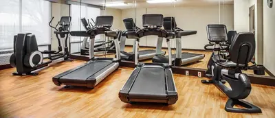 a gym with several treadmills and elliptical machines at Hyatt Place Cincinnati Blue Ash in Blue Ash