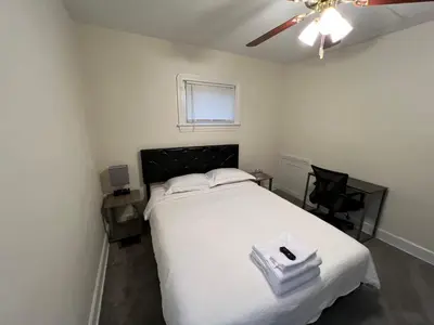 a bedroom with a white bed and a ceiling fan at StayWithJay Premium Furnished Room near Cleveland Airport in Cleveland