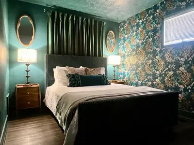 a bedroom with a bed with a floral wallpaper at Fauver Suite in Dayton