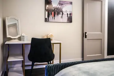 a bedroom with a desk and a chair and a mirror at Fauver Suite in Dayton