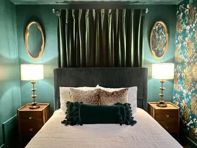 a bedroom with a bed with two lamps and two mirrors at Fauver Suite in Dayton