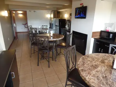 a kitchen and dining room with tables and chairs at Super 8 by Wyndham Beaver Falls in Beaver Falls