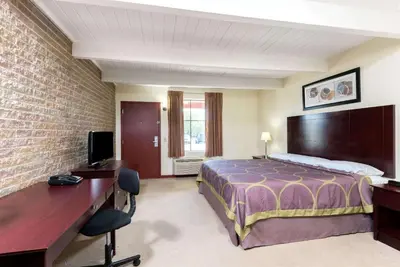 a hotel room with a bed and a desk and a television at Super 8 by Wyndham Beaver Falls in Beaver Falls