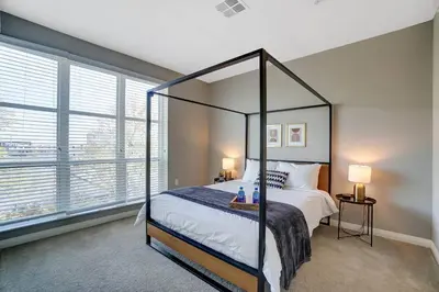 a bedroom with a canopy bed and a large window at The Urban Oasis Garage Parking Walk-In Shower in Columbus