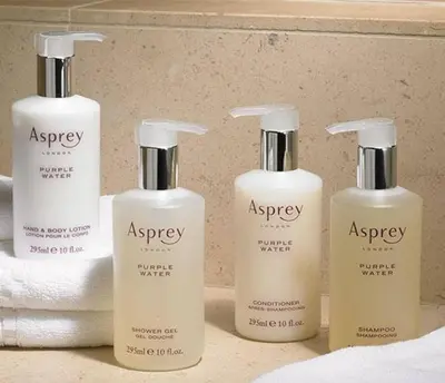 a group of four shampoo bottles sitting on a bathroom counter at The Urban Oasis Garage Parking Walk-In Shower in Columbus