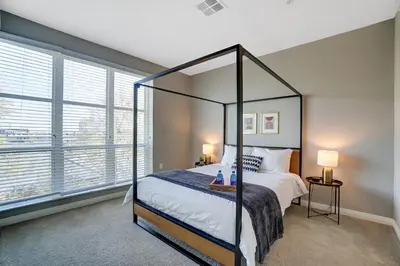 a bedroom with a canopy bed and a large window at The Urban Oasis Garage Parking Walk-In Shower in Columbus