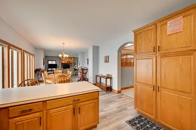 a kitchen with wooden cabinets and a dining room at Hot Tub and Dock Waterfront Lake Hamilton Home in Hamilton