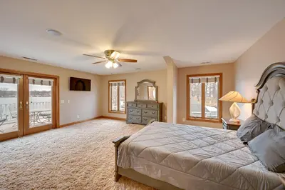 a bedroom with a bed and a ceiling fan at Hot Tub and Dock Waterfront Lake Hamilton Home in Hamilton