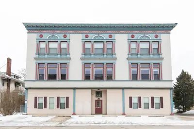 a large white building with red windows at The Jazz Club Downtown Sandusky in Sandusky