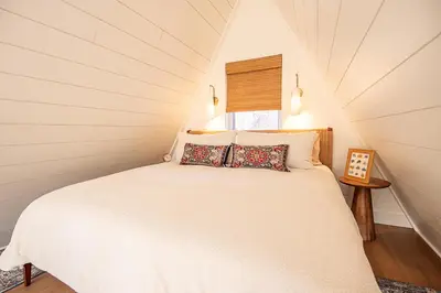 a bedroom with a white bed in a attic at Cherry Hollow in McArthur