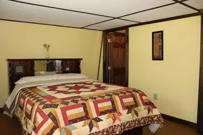 a bedroom with a bed with a quilt on it at East Fork Acres in Logan