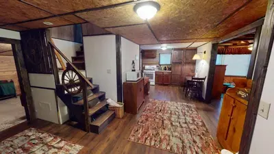 a living room with a staircase in a house at East Fork Acres in Logan