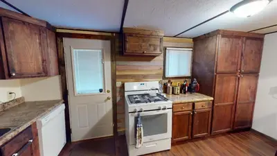 a kitchen with wooden cabinets and a stove top oven at East Fork Acres in Logan