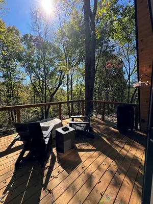 a deck with two chairs and a bench on it at Hickory Hollow in McArthur