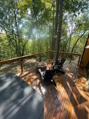 a wooden deck with a table and a chair on it at Hickory Hollow in McArthur