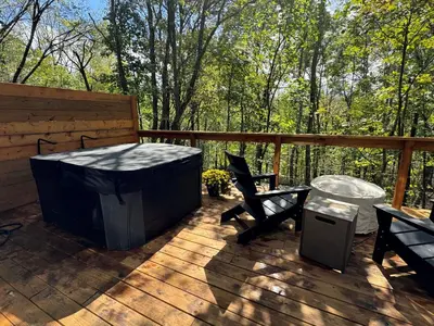 a deck with a hot tub and a table and chairs at Hickory Hollow in McArthur