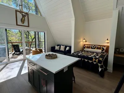 a kitchen and living room with a bed in a room at Hickory Hollow in McArthur