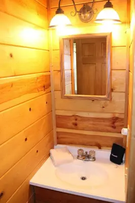 a bathroom with a sink and a mirror at Jack Pine Hollow in Logan