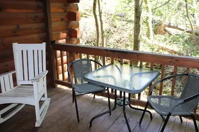a table and chairs on a porch of a cabin at Jack Pine Hollow in Logan