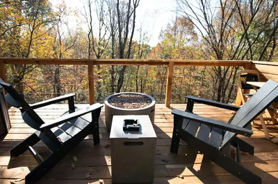 two chairs and a table on a wooden deck at Oak Hollow in McArthur