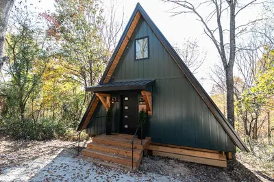a green cabin with a gambrel roof at Oak Hollow in McArthur
