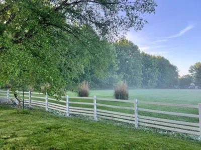 a white fence in front of a field at Winifreds Hideaway in Berea