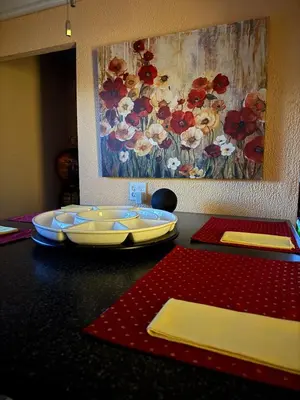 a table with two plates and a painting of flowers at Winifreds Hideaway in Berea