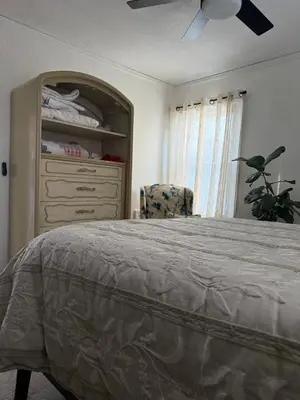 a bedroom with a bed and a dresser and a chair at Winifreds Hideaway in Berea