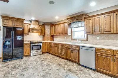 a kitchen with wooden cabinets and white appliances at Meadow Edges with Yard and Views in Odon in Sunman