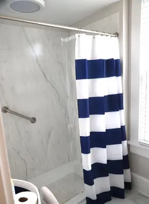 a bathroom with a shower with a blue and white shower curtain at Werner Haus in Sandusky